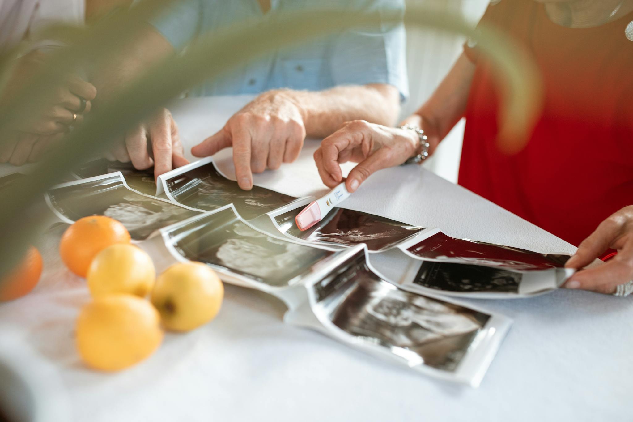 Family members examine ultrasound images and a pregnancy test at home, highlighting excitement and anticipation.